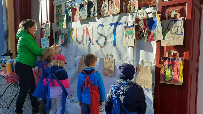 Auf dem Bild sind Kinder zu sehen die Papiertüten bemalen. Auf dem Bild sind Kinder zu sehen die Papiertüten bemalen.