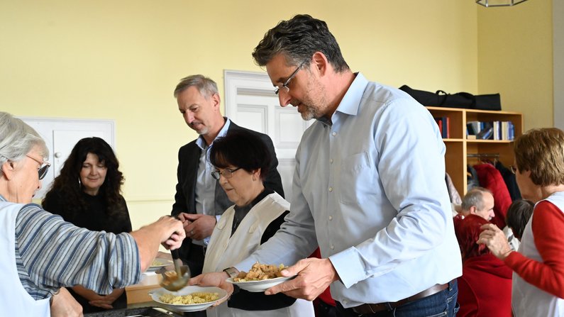 Auf dem Bild sind Personen zu sehen, die Essen verteilen. Auf dem Bild sind Personen zu sehen, die Essen verteilen.