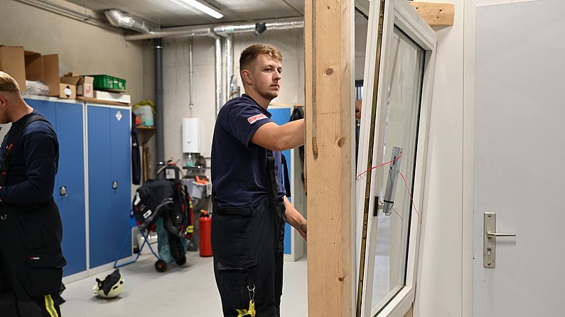 Auf dem Foto sieht man einen Mann, der ein Fenster - mittels Hilfsmitteln öffnet. 
