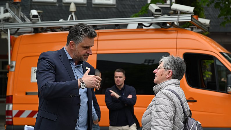 Auf dem Bild ist Bürgermeister Frank Spilling im Gespräch mit einer Bürgerin zu sehen. 