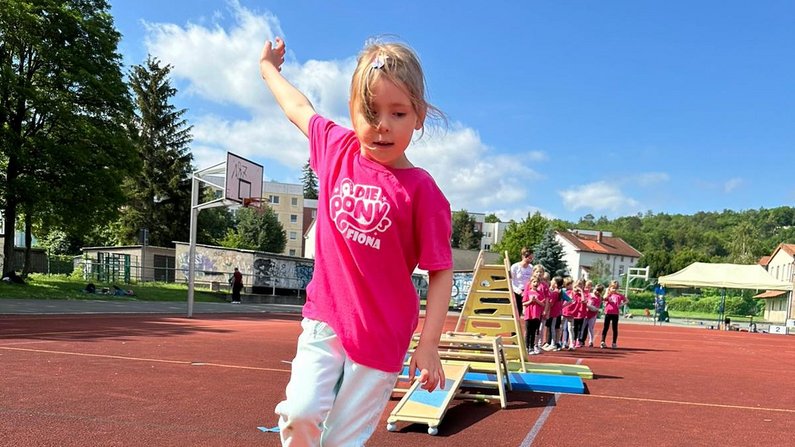 Auf dem Bild ist ein Kind beim Sportfest zu sehen. 