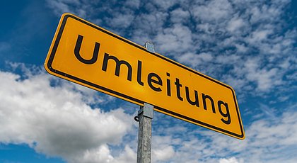 Das Foto zeigt ein gelbes Schild mit der Aufschrift Umleitung